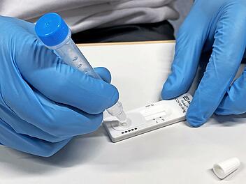 Ein BRK-Mitarbeiter führt einen Corona-Test durch.