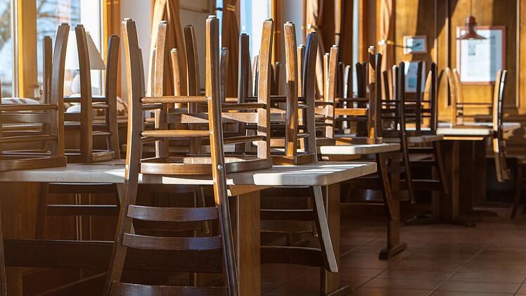 Stühle stehen auf Tischen in einem geschlossenem Restaurant. Speisesaal, Gaststätte, Gasthaus, Gasthof, Wirtschaft, Restaurant, Lokal, Gastronomiebetrieb