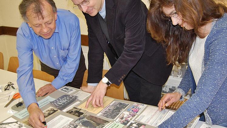 Hans Georg Keßler (von links), Kaplan Paul Reder und Gabriele Müller gestalten eine Ausstellungstafel über Julius Kardinal Döpfner, der vor 40 Jahren starb. Foto: Sigismund von Dobschütz