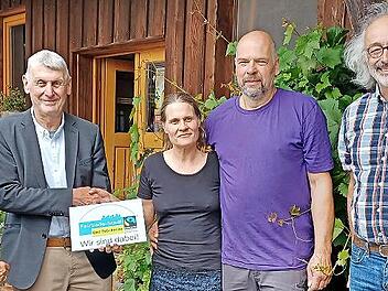 Jürgen Pfister, Zweiter Bürgermeister von Bad Brückenau, überreicht Ludwig Weber, Inhaber des Steffeshofs, die Plakette mit dem Fairtrade-Emblem: (von links) Martina Kirchner (Weltladen), Jürgen Pfister, Sabine Friedrich (Hofladen), Ludwig Weber (...