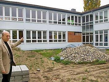 Rektor Friedrich Tasch zeigt auf zugemauerte Fenster und Steinhaufen im Innenhof der Schule. Hier wird ein stählerner Rundlauf eingebaut, ein schneller Fluchtweg für den Notfall, der hoffentlich nie eintritt.