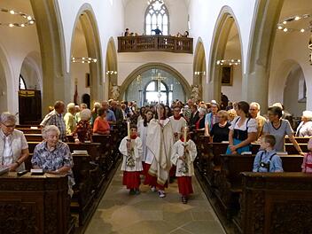 Mit dem Kreuz vorweg zogen die Gläubigen wieder in ihr saniertes Gotteshaus ein. Fotos: Marion Krüger-Hundrup
