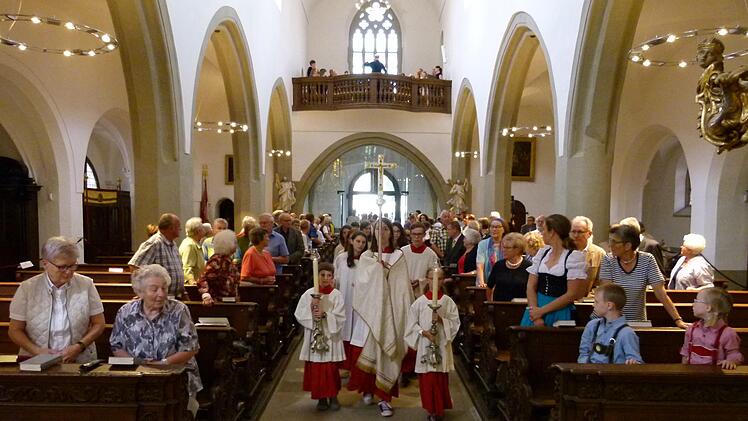 Mit dem Kreuz vorweg zogen die Gläubigen wieder in ihr saniertes Gotteshaus ein. Fotos: Marion Krüger-Hundrup