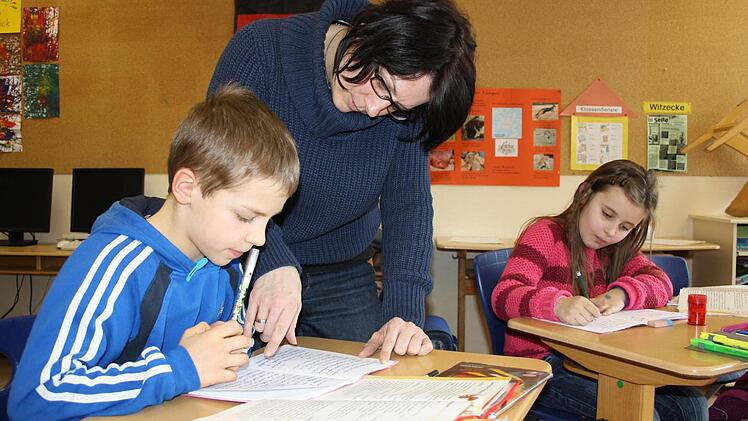 Bad Brückenau: Erzieherin Silke Helget betreut unter anderem die beiden Drittklässler Tim und Laura bei den Hausaufgaben, bevor gespielt wird. Foto: Ralf Ruppert/Archiv Saale-Zeitung