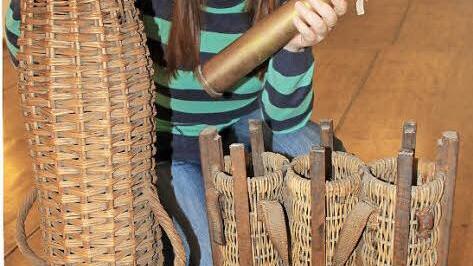 Ariane Schmiedmann vom Deutschen Korbmuseum in Michelau zeigt einige der Exponate - Geschosskörbe der verschiedenen Größen und eine Artilleriegranate, für deren sicheren Transport die Körbe bestimmt waren. Foto: Matthias Einwag