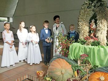 Wortgottesleiterin Maria Kienzle segnete zusammen mit den Kommunionkindern, die in ihrer Kommunionkleidung dem Fest einen feierlichen Charakter verliehen, den Erntealtar. Das Bild zeigt (von links) Emilia M&auml;tzold, Lina Lubig, Mona Braunersreuther, Adam Pekny, Maria Kienzle und David Pekny.