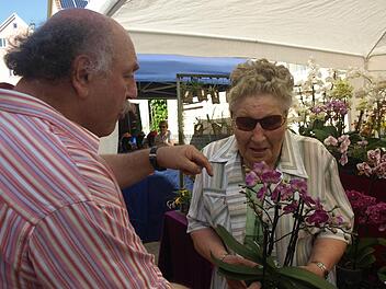 Züchter Kurt Beck erklärt Elvira Stockheimer beim Ebenhäuser Pfingstmarkt, wie die Pflege von Orchideen funktioniert.  Fotos: Stefan Geiger
