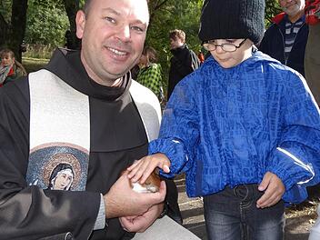 Der fünfjährige Fabian Wehner aus Münnerstadt hatte seine Meerschweinchen zur Tiersegnung mitgebracht. Pater Stanislaus nahm sich extra Zeit die kleinen Vierbeiner aus dem Käfig zu nehmen.  Foto: Marion Eckert