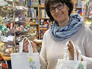 Birgit Brehm zeigt zwei Stofftaschen, die Kinder bei der letzten Himmelswerkstatt bemalt haben.  Foto: Tina Meier