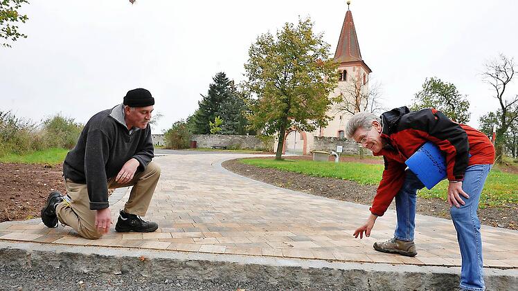 Hans Ziegelmeier (rechts) und  Reinhard Schierer prüfen das Pflaster des neuen Wegs zu Johanniskirche.  Foto: Ronald Rinklef