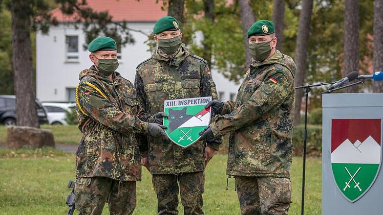Hauptfeldwebel Maik Schrecke, Oberstleutnant Andreas Eichhorn und Major Andreas Mathes mit dem Abzeichen der neuen Inspektion.  Foto: Bundeswehr/Benjamin Bendig