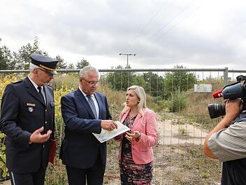 Noch liegt die  Fläche am Tännig (im Hintergrund) brach - auf dem Grundstück im Süden von Bamberg sollen  Verkehrs- und Landpolizei unterkommen.  Innenminister Herrmann (Mitte) bekräftigte mit Ministerin Melanie Huml und Polizeivizepräsident Udo Skrzypczak die Pläne.  Foto: Barbara Herbst