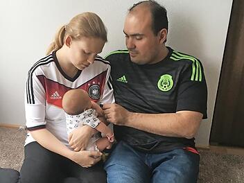 Sandra Krämer und Alejandro Perez drücken zwar verschiedenen Mannschaften die Daumen, die kleine Elisa trägt aber noch einen neutralen Strampler zur WM.  Foto: privat