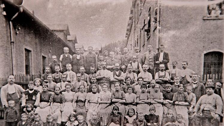 Die Belegschaft der Firma Benda um 1920, links die Produktionsst&auml;tte, rechts die Wohnungen der Arbeiterfamilien. Foto: Gemeindearchiv Marktschorgast