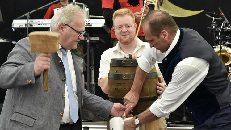 Bürgermeister Claus Bittenbrünn (links) sticht das erste Fass Bier an.
