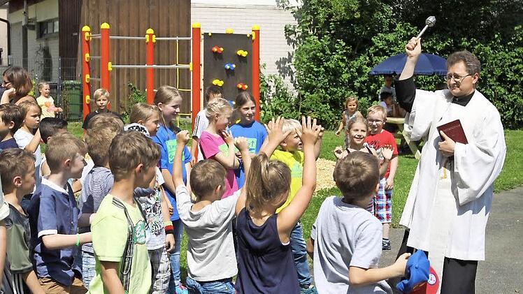 Der Pfarrer Jan Poia segnete den neuen Spielplatz, auf den sich die Kinder gefreut haben. Foto: Michael Wunder