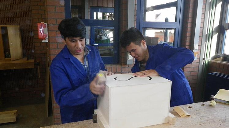 Die einen haben keine Ausbildung, die anderen keine Azubis: Frankens Handwerker sehen in den Flüchtlingen eine Chance gegen den Nachwuchsmangel. Diese zwei Jugendliche bauen in der Berufsschule Bamberg eine Kistentrommel.  Foto: p.