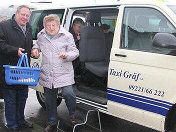 Beim ersten Mal hilft Bürgermeister Volker Schmiechen der 79 Jahre alten Else Kaluz aus dem Bürger-Taxi. Sie stieg am Eichberg zu. Foto: Sonja Adam