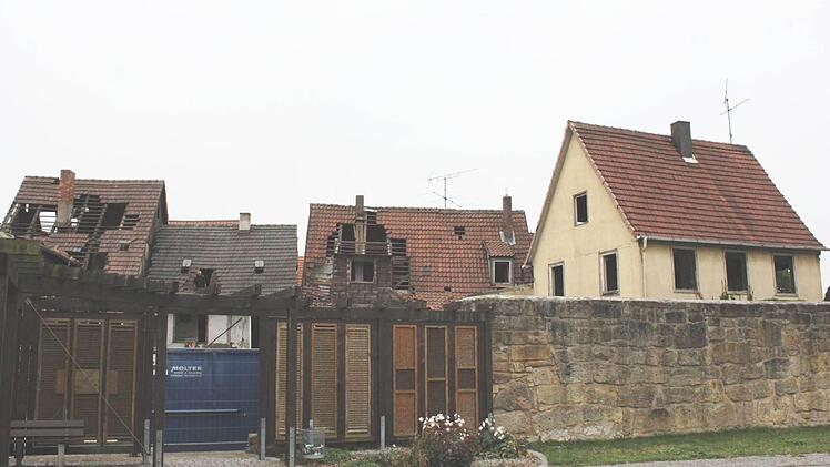 Im Durchgang von der Grünfläche im Bürgerweg zur Kirchgasse steht eine blaue Mulde, in der Schutt gesammelt wird. Der Rückbau der Häuser ist schon von weitem erkennbar. Popp