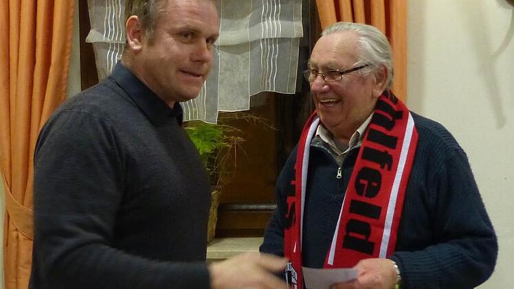 Martin Schiepek händigt Marian Sypien, der die Spielvereinigung im Jahr 1946 mitgründete, den ersten Vereinsschal aus. Foto: Pauline Lindner