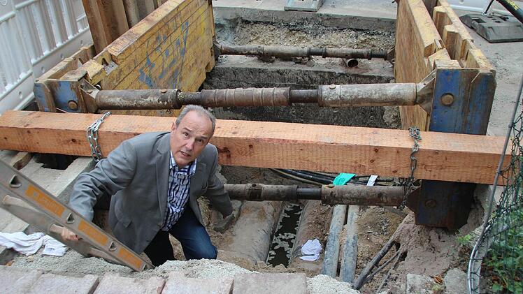 ZAW-Werkleiter Peter Baj zeigt die Stelle, wo der Bohrkopf die Fernwärmerohre beschädigt hat. Etwa dort, wo das weiße Stoffstück liegt, wurden die Glasfaserkabel direkt unter den dicken Fernwärmerohren hindurchgeschossen. Foto: Ulrike Nauer