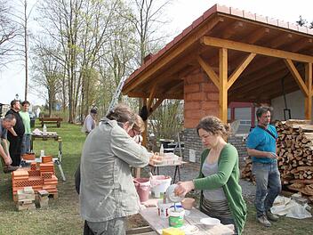 Die Seminarteilnehmer haben einen Holzbrennofen (rechts im Hintergrund) gebaut und bereiten Tonwaren fürs Brennen vor. Foto: Jürgen Gärtner