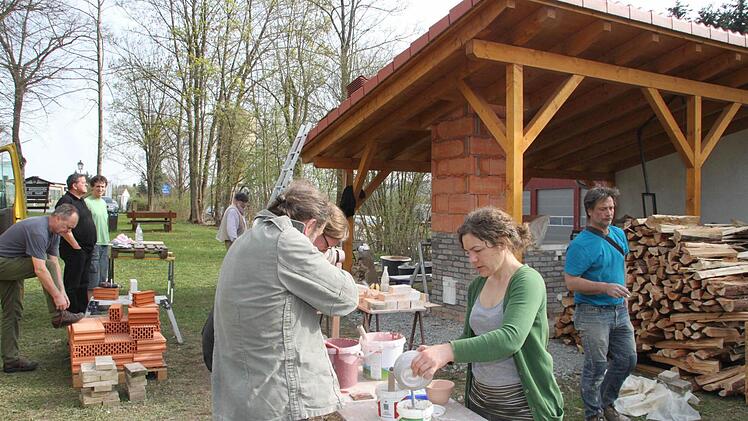 Die Seminarteilnehmer haben einen Holzbrennofen (rechts im Hintergrund) gebaut und bereiten Tonwaren fürs Brennen vor. Foto: Jürgen Gärtner