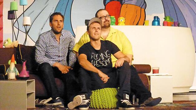 Einiges von der Erstausstattung f&uuml;r den erwarteten 1,5-J&auml;hrigen steht noch rum, aber der 15-J&auml;hrige sitzt eintr&auml;chtig mit seinen beiden schwulen Papas auf dem Sofa und schaut Dias von ihrer Hochzeit mit ihnen an. Das Publikum im Kurtheater am&uuml;sierte sich ausgezeichnet mit Jan Hasenfu&szlig; (links), Stefan Pescheck (Mitte) und Thomas Rohmer. Foto: Gerhild Ahnert