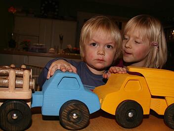 Schönes Holzspielzeug made by Papa. Der blaue Holzlaster hat den Namen 'Jan'. Mit Holz beladen hängt der Hänger 'Erik' dran. Der gelbe Kipper, trägt den Namen Björn. Die beiden Laster haben eine Karambolage hingelegt: Der zweijährige Jakob und seine fünfjährige Schwester Jule haben richtig Spaß mit den von Papa gemachten Spielsachen, denn die sind unverwüstlich.