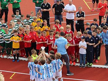 Bei der Siegerehrung in Baunach bejubeln die F-Jugend-Fußballer des TSV 1860 München (vorne, blau-weiß gestreifte Trikots) ihren Pokalsieg.