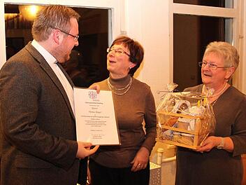 Pfarrer Thomas Ringer freut sich über die Urkunde zur Ernennung zum Geistlichen Beirat, überreicht von Maria Zahnleiter, sowie über das Geschenk fürs leibliche Wohl, überreicht von Maria Schockel  Foto: Johanna Blum