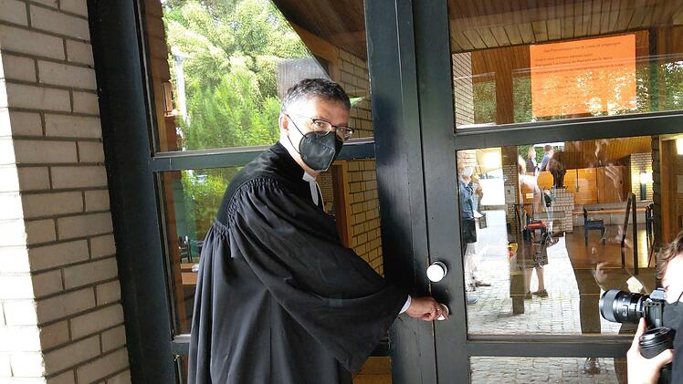Pfarrer Rolf Roßteuscher sperrt symbolisch die Kirche zu. Foto: Simone Bastian