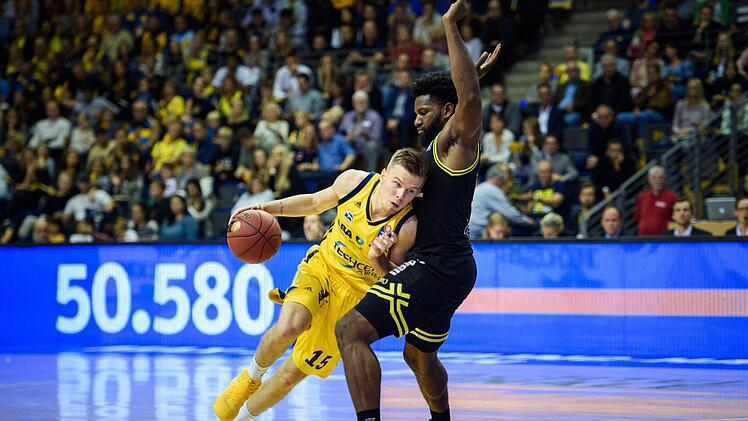 Berlins Martin Hermannsson (l) umkurvt mit dem Ball Bayreuths Hassan Martin. Foto: Gregor Fischer/dpa