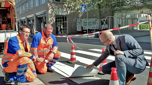 Oberb&uuml;rgermeister Dirk Vogel (rechts) l&auml;sst sich von den Servicebetrieb-Mitarbeitern David Reu&szlig; (links) und Sebastian Metz eine thermoplastische Kunststoffplatte zeigen.