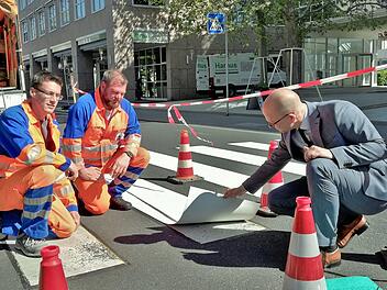 Oberbürgermeister Dirk Vogel (rechts) lässt sich von den Servicebetrieb-Mitarbeitern David Reuß (links) und Sebastian Metz eine thermoplastische Kunststoffplatte zeigen.