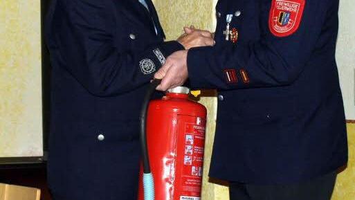 Ehrenkommandant Ludwig Gleich (links) erhielt zu seinem Feuerwehrjubiläum von Kommandant Ralf Fischer (rechts) einen Feuerlöscher der etwas anderen Art. Fotos: Susanne Deuerling