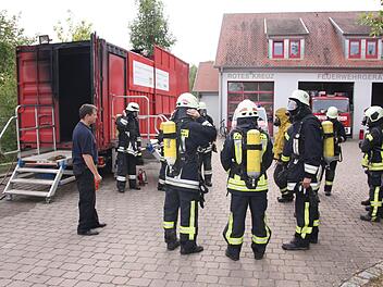 Kreisbrandmeister Guido Schneider beobachtet das Anlegen der Schutzkleidung, vor dem noch kalten Brandcontainer. Auch der Ausbilder der Firma Dräger (4. von rechts) hat sich ordentlich gerüstet. Matthias Nöth