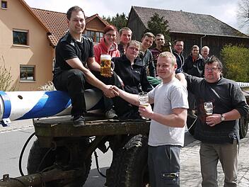 Einigung per Handschlag: Benjamin Otto (vorne, links) und Christoph Haas (rechts) haben die Auslöse ausgehandelt. Dass die Landjugend Meeder beim Aufstellen des Maibaumes mithalf und danach noch ein bisschen mit den Wohlbachern feierte, versteht sich von selbst. Foto: Berthold Köhler