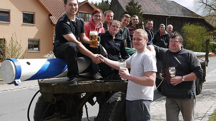 Einigung per Handschlag: Benjamin Otto (vorne, links) und Christoph Haas (rechts) haben die Auslöse ausgehandelt. Dass die Landjugend Meeder beim Aufstellen des Maibaumes mithalf und danach noch ein bisschen mit den Wohlbachern feierte, versteht sich von selbst. Foto: Berthold Köhler