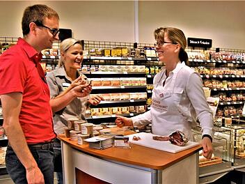 Bezirksleiter Karsten Lindlein und Marktleiterin Doreen Schuba (Mitte) verkosten im Biomarkt bei Silvia Kleinhenz die Schinkenspezialitäten der Landmetzgerei Kleinhenz.  Foto: Sigismund von Dobschütz