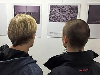 Jonas Glöckner und Janik Scholz studieren Fotos und Texte der Ausstellung, die in Porto mit Fotos aus Polen gezeigt wurde.  Foto: Gymnasium Haßfurt