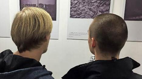 Jonas Glöckner und Janik Scholz studieren Fotos und Texte der Ausstellung, die in Porto mit Fotos aus Polen gezeigt wurde.  Foto: Gymnasium Haßfurt