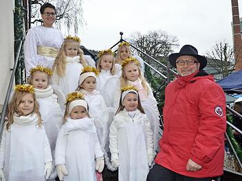 Sie ließen sich trotz Regens die gute Laune zur Weihnachtsmarkteröffnung im "Paradies" nicht verderben. Bei der Eröffnung, das Christkind Julia Kalb (oben links) und Bürgermeister Egon Herrmann (r.) mit den Engeln von der Grundschule Weißenbrunn Foto: K.- H. Hofmann