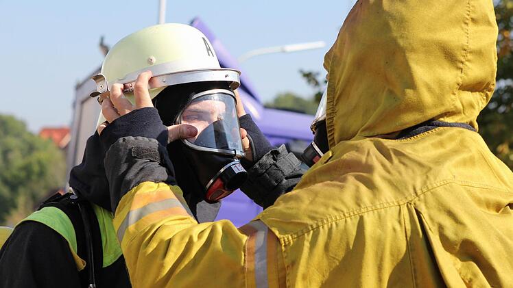 ... überprüfen die Feuerwehrmänner gegenseitig ihre Atemschutzgeräte.