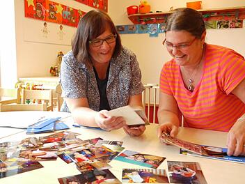 Die Erzieherinnen der ersten Stunden Maria Schüpferling (links) und Birgit Kastner schauen die alten Fotos an.  Fotos: Pauline Lindner