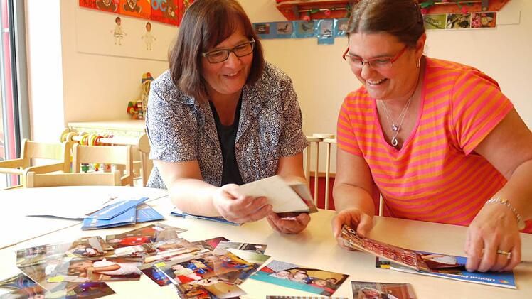 Die Erzieherinnen der ersten Stunden Maria Schüpferling (links) und Birgit Kastner schauen die alten Fotos an.  Fotos: Pauline Lindner