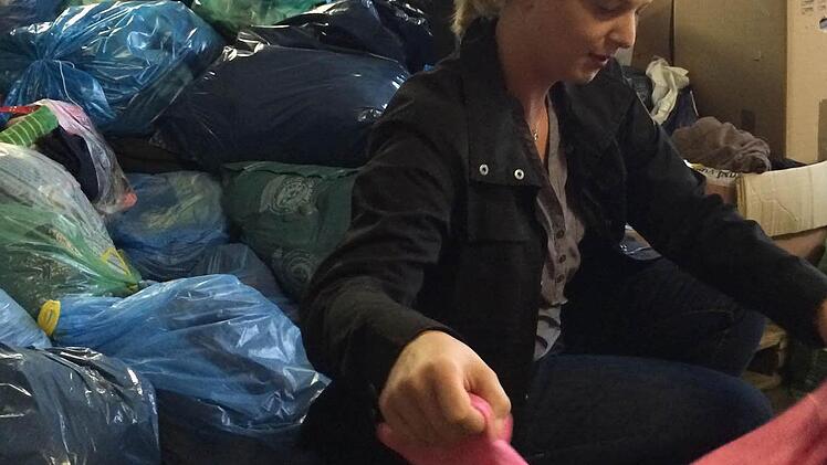 Miriam Schirmer sortiert Kleiderspenden.