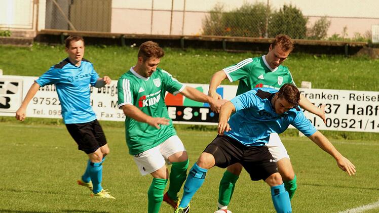 Geschickt schirmen die beiden Sander Stefan Wasser (rechts) und Florian Pickel (Dritter von rechts) den Rimparer Philip Löw ab.