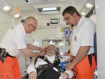 Die praktische Vorgehensweise im Rettungswagen demonstrierten Rettungssanitäter Sascha Schulz (rechts) und Rettungsassistent Mark Maksymin mit Sofortmaßnahmen einer Infusion und Blutdruckmessung bei Pater und "Patient" Helmut Haagen. Foto: Karl-Heinz Hofmann