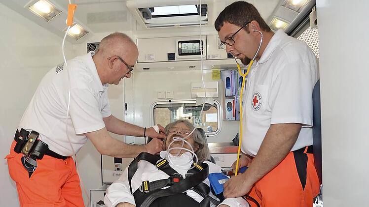 Die praktische Vorgehensweise im Rettungswagen demonstrierten Rettungssanitäter Sascha Schulz (rechts) und Rettungsassistent Mark Maksymin mit Sofortmaßnahmen einer Infusion und Blutdruckmessung bei Pater und "Patient" Helmut Haagen. Foto: Karl-Heinz Hofmann